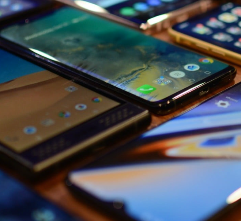 A close-up of various smartphones displayed on a surface.